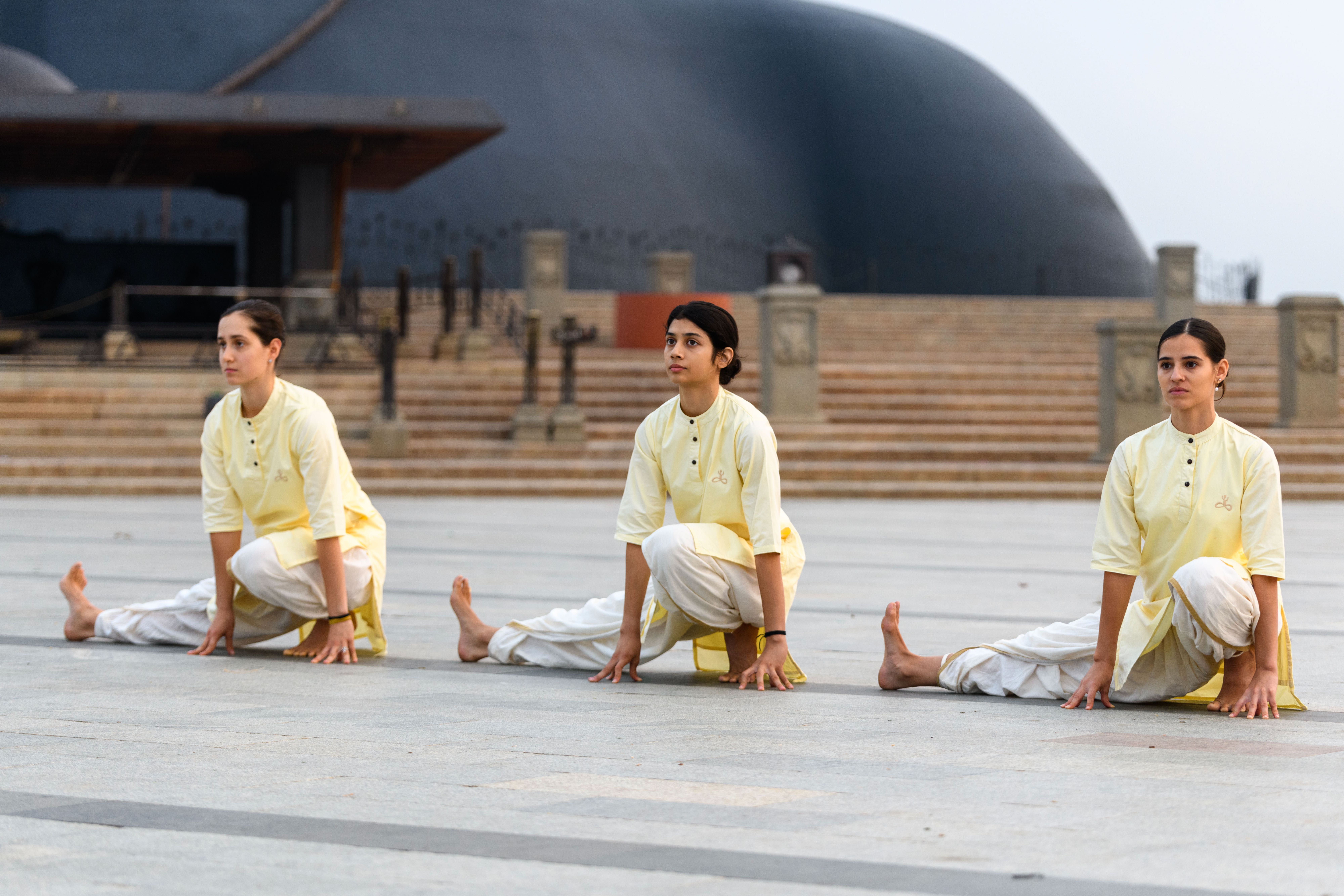 Yoga practitioners in synchronized practice at sunrise
